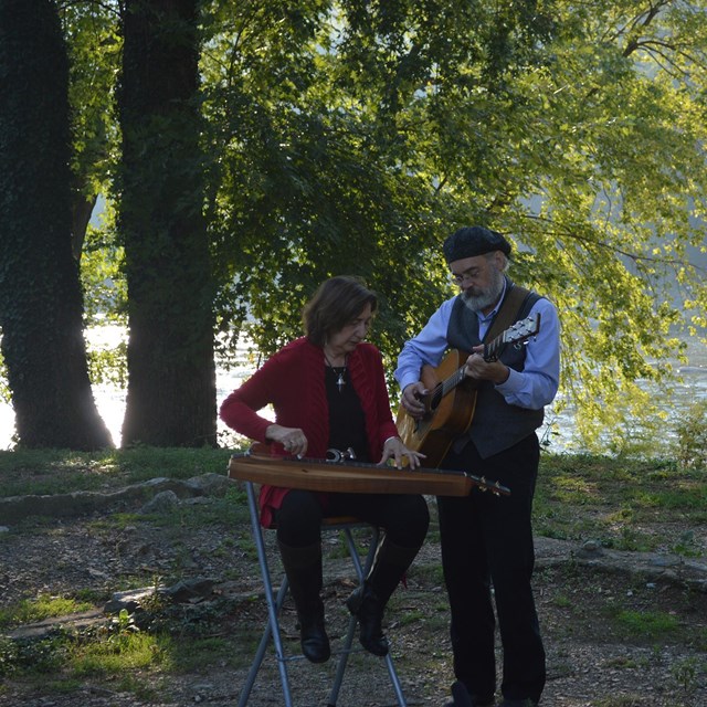 photo of Terry Leonino and Greg Artzner of Magpie, playing instruments near the Shenandoah River
