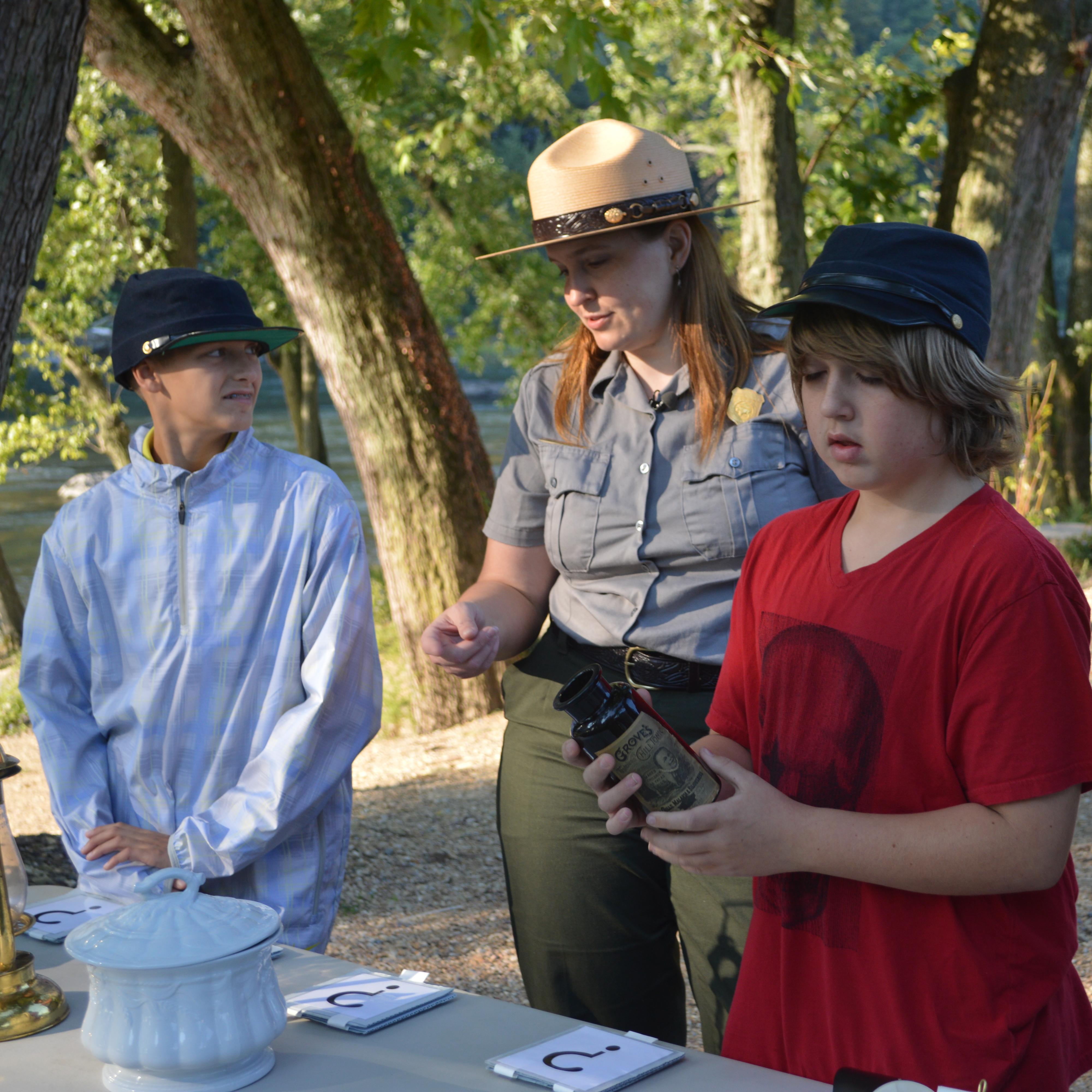 park ranger and students looking at objects