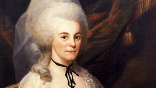 Elizabeth Schuyler Hamilton painting; she sits in a silver dress with a large white hairstyle.