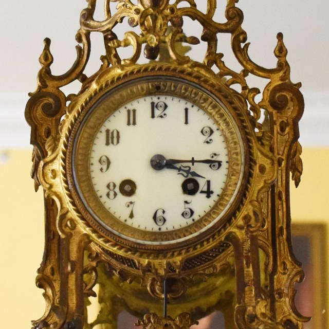 A gold and ornately designed clock.