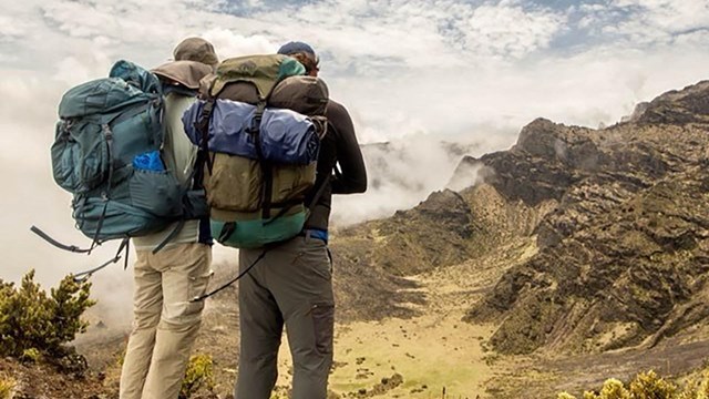 Two backpackers stand at edge of crater trail.