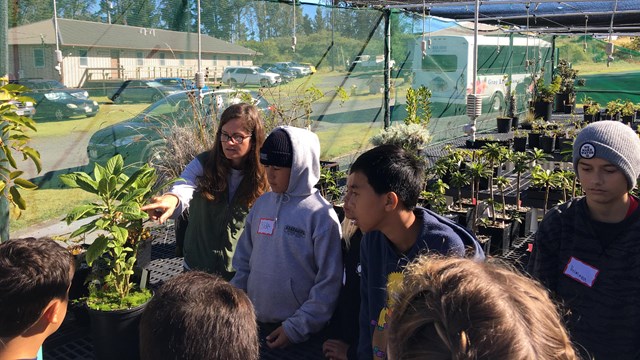 A ranger leads students in the greenhouse