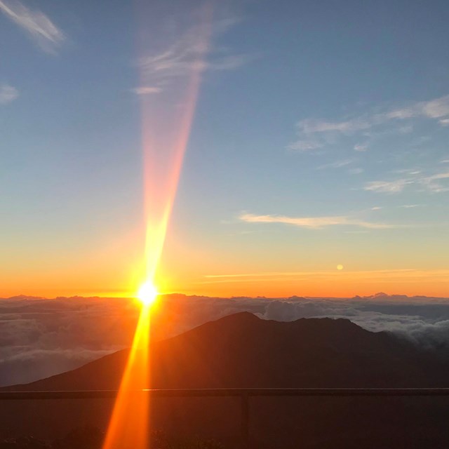 The sun rises over the edge of the crater