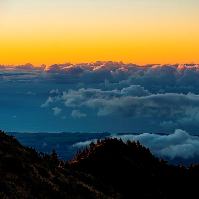 The sun rises over the edge of the crater