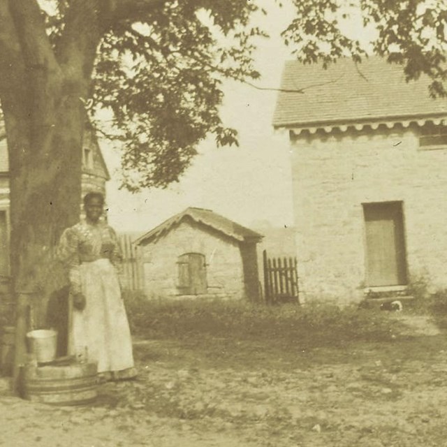 c. 1897 image of a tenant farmer woman outside the Enslavement Quarters. NPS