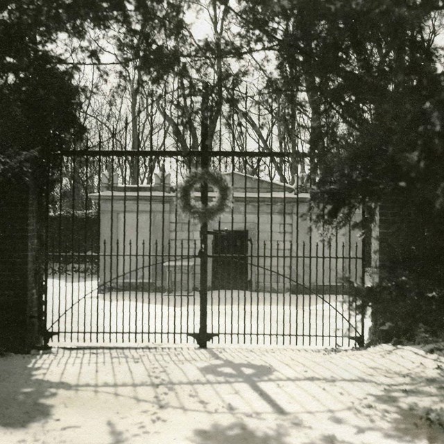 Black and white historic image of the cemetery gates.