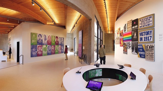 A large exhibit room with a round desk and posters on the walls.