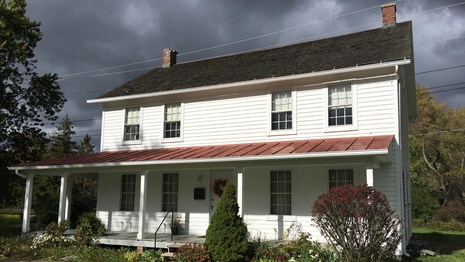White two-story home with front porch.