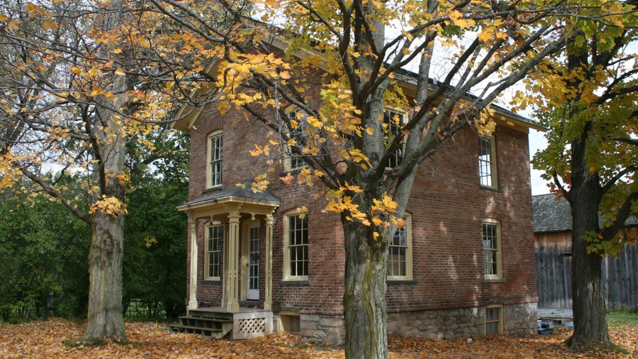 color photo Harriet Tubman's two-story colonial brick residence in autumn.