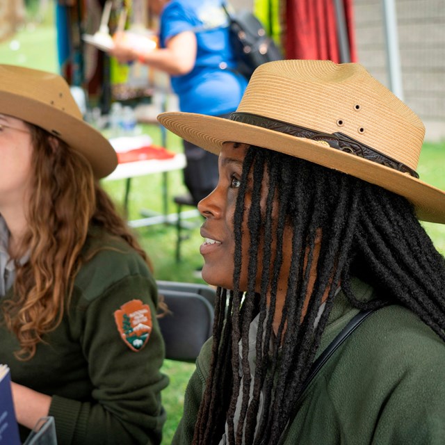 Two rangers sitting at a table outdoors