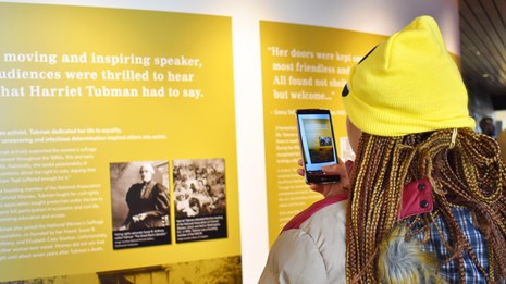Woman taking photo of exhibit panel