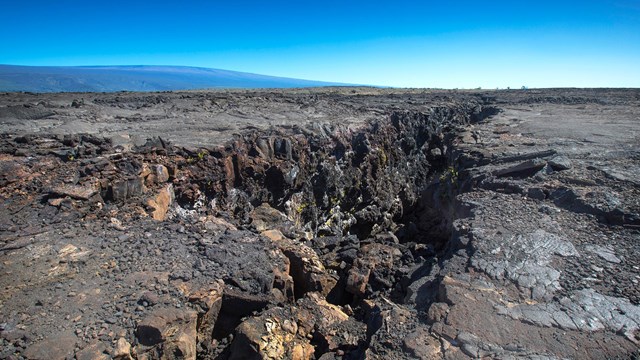 A large crack in a volcanic lava field. 