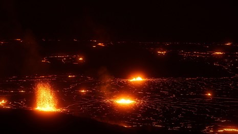 A lava lake produces several lava fountains at night. 