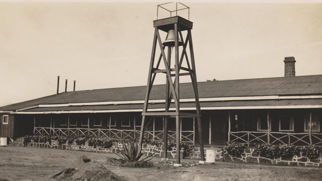 Black and white photograph of a building and a bell tower