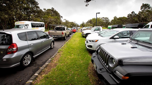 Road with cars parked on the side and in an adjacent parking lot