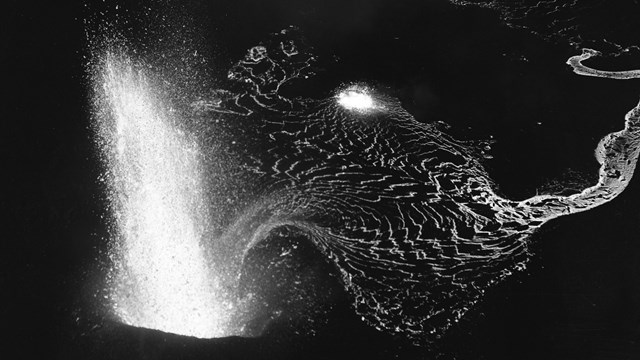 Black and white photo of a lava fountain from above at night