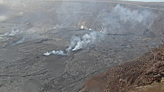A volcanic cinder cone emitting steam. 