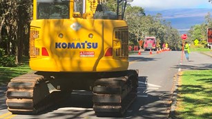 Excavator and semitruck on Crater Rim Drive fixing the road.