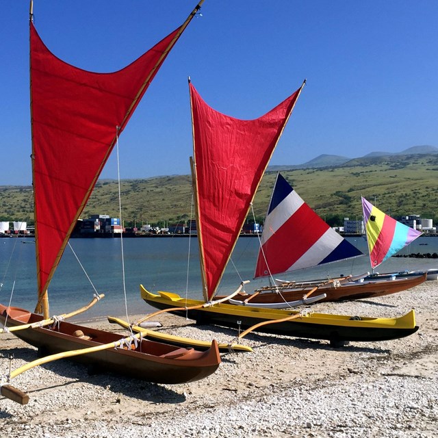 red traditional hawaiian canoes on beach
