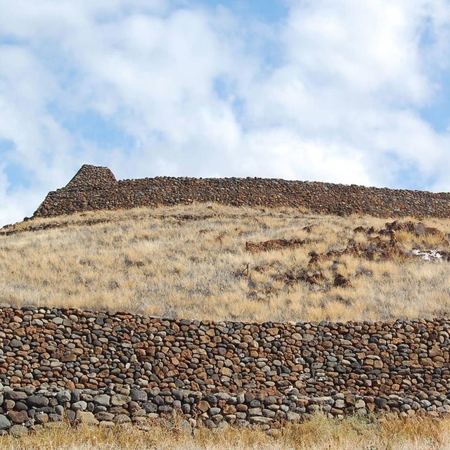 a human-made rock plateau sits atop a grassy hill