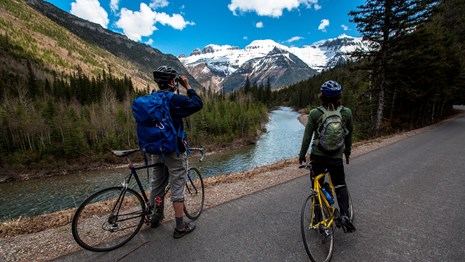 Two bicyclists standing on road