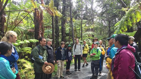 Ranger speaking to young adults on hiking path in the forest