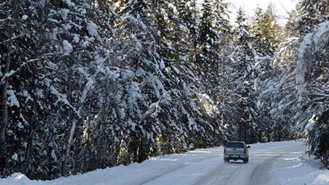 Car driving on a snow covered road in Glacier National Park