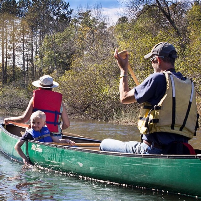 Group of people paddling in canoes wearing life jackets