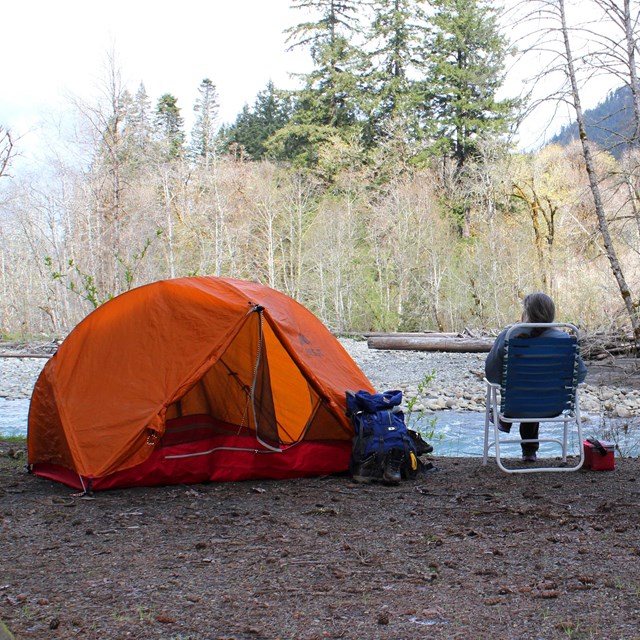 Camper siting by tent 