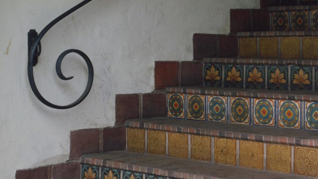 Tile staircase with curved wrought-iron hand rail