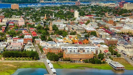 Ariel photo of city of Charleston surrounded by the ocean.
