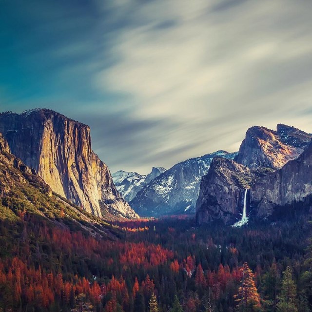 Tall mountain tops with a waterfall and valley below. 