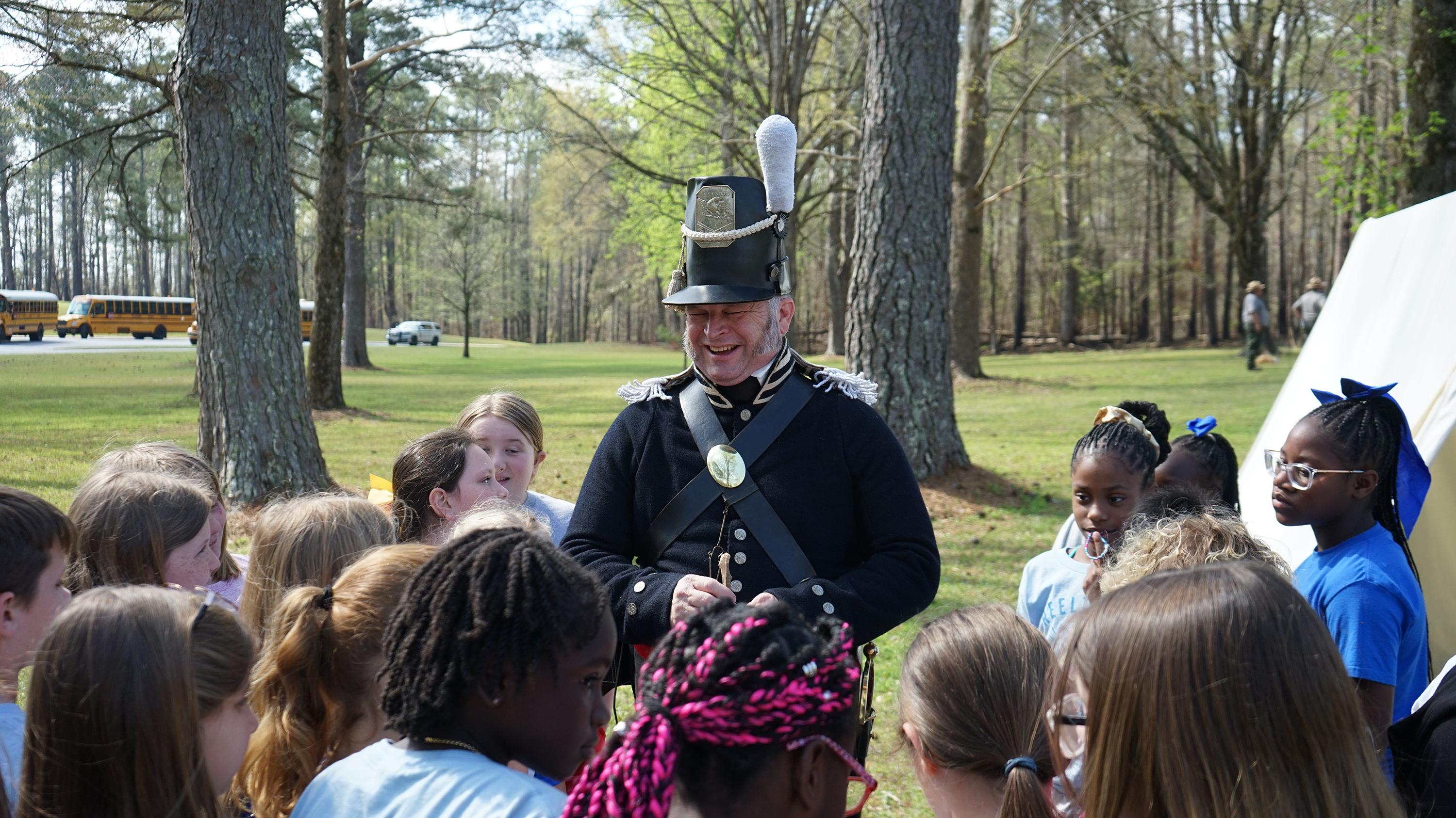 A reenactor laughing with students during a presentation at Horseshoe Bend NMP.