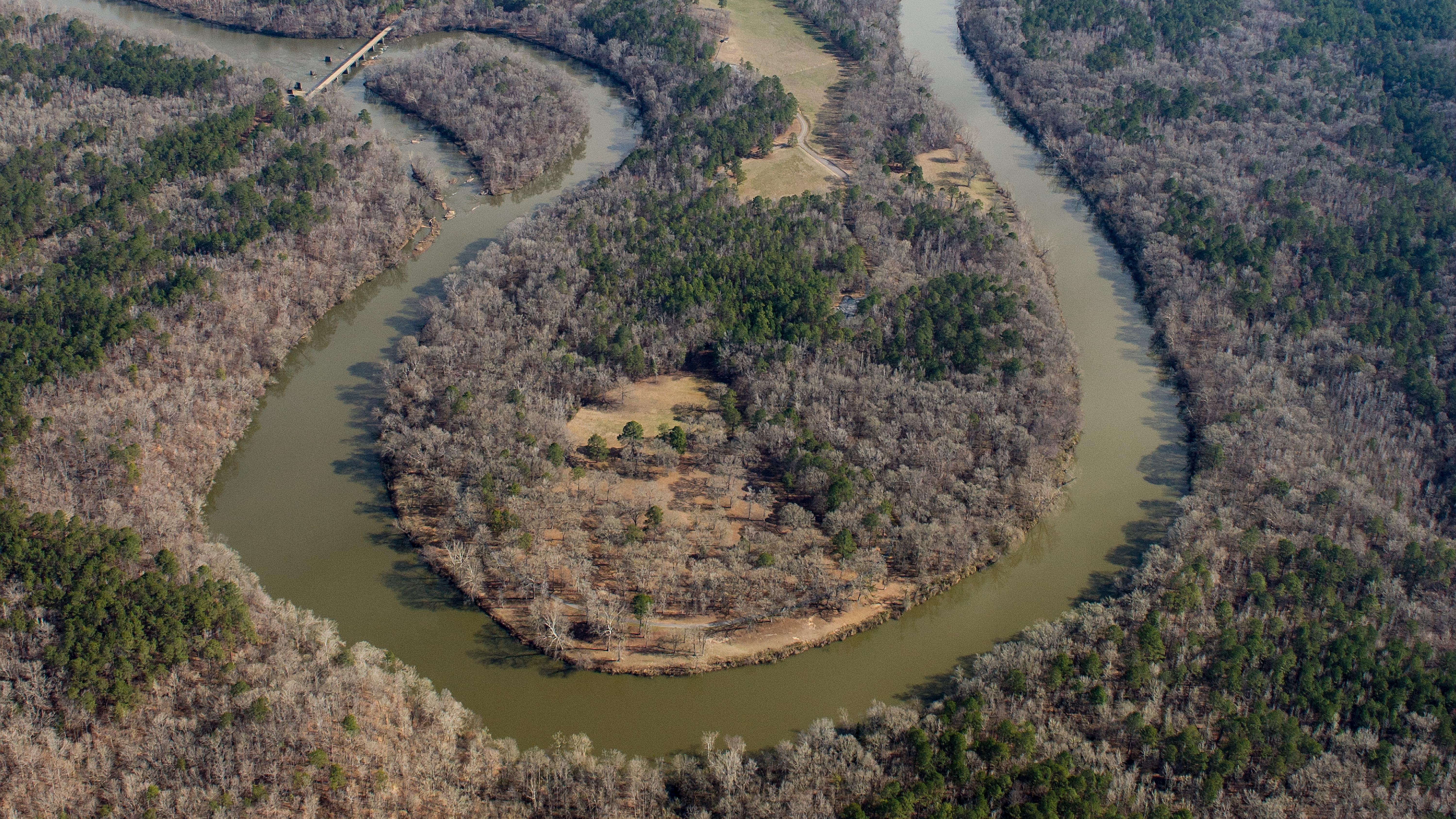 An aerial view of the horseshoe-shaped bend of the tallapoosa river. It is surrounded by pine forest