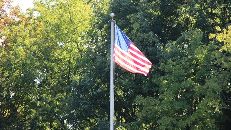 A U.S. flag flies in the wind on a flagpole