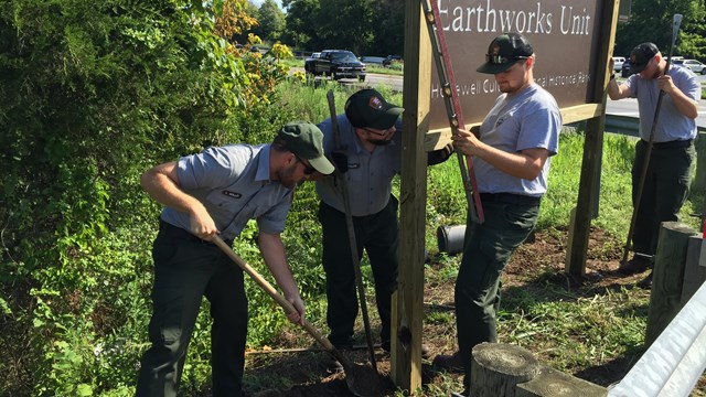 Several workers erecting a new sign