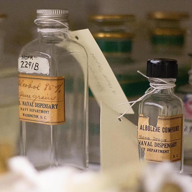 An assortment of class medicine bottles with labels and tags.