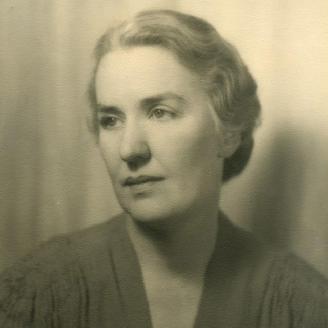 A head and shoulders portrait of a woman with hair pulled back.