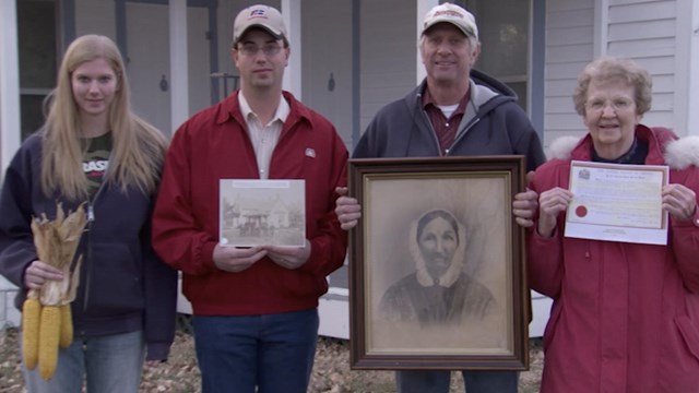 3 generations of homesteaders pose in front of homestead