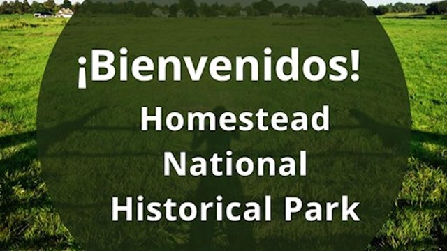 Grassy field with Spanish text bubble "Bienvenidos Homestead National Historical Park"
