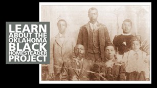 A family of black homesteaders pose for a photo dressed in formal attire.