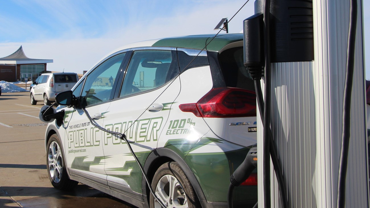 An electric vehicle parked and plugged into a charging station.