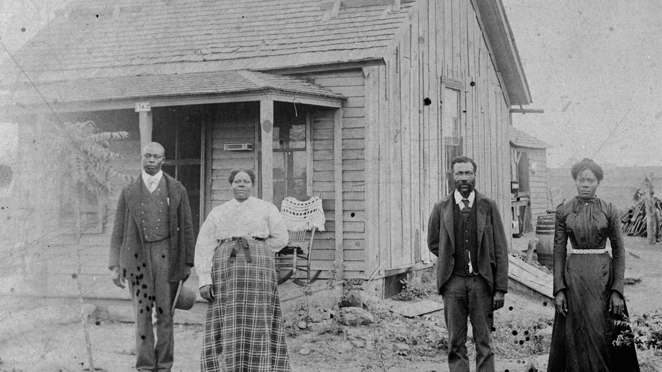 Four people standing outside a building