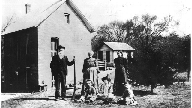 Family posing for a photo in front of their homestead