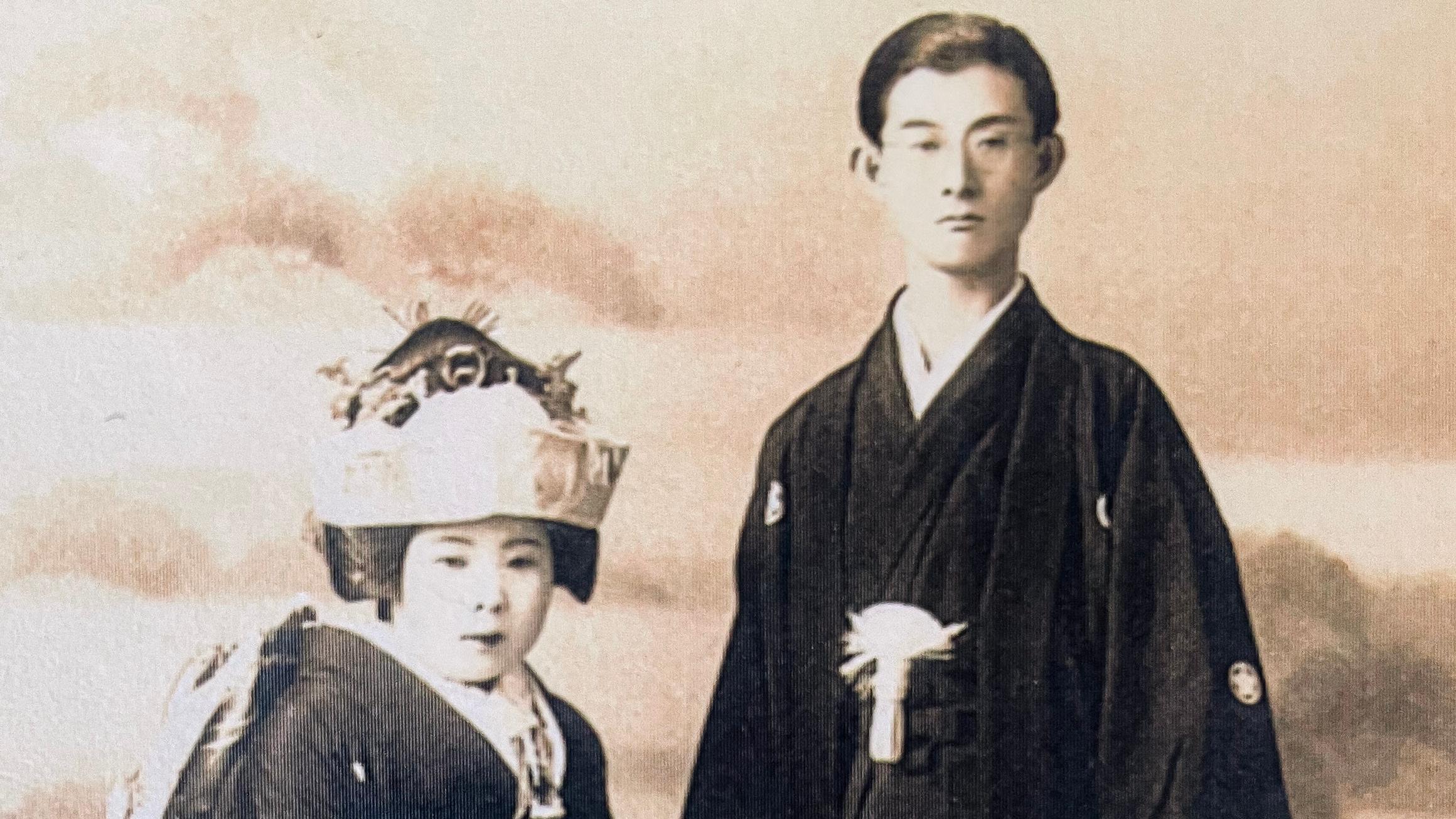 A Japanese man and woman posing in traditional wedding attire.