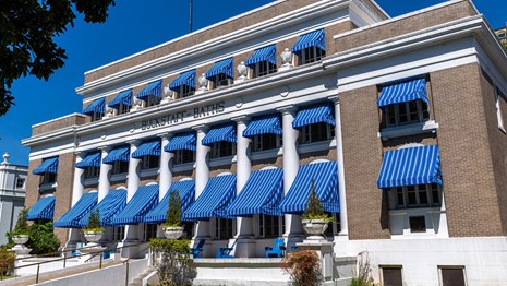 The Buckstaff Bathhouse standing tall featuring its iconic bright blue awnings.