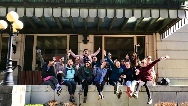 A group of women excitedly pose outside the Fordyce Bathouse.