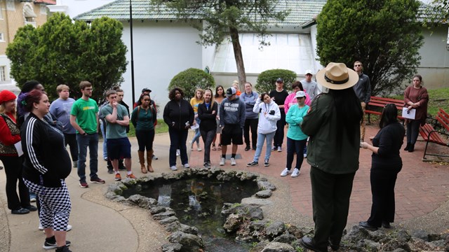 A female ranger delivers a program near one of the thermal springs.