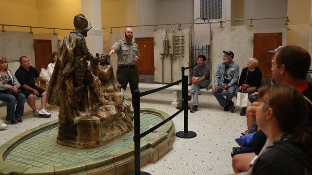 A park ranger speaks to a group of visitors on a tour of the Fordyce Bathhouse