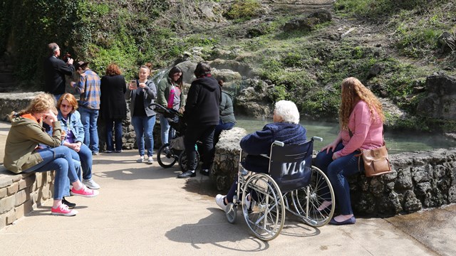 Visitors enjoy standing and sitting near the Hot Water Cascade